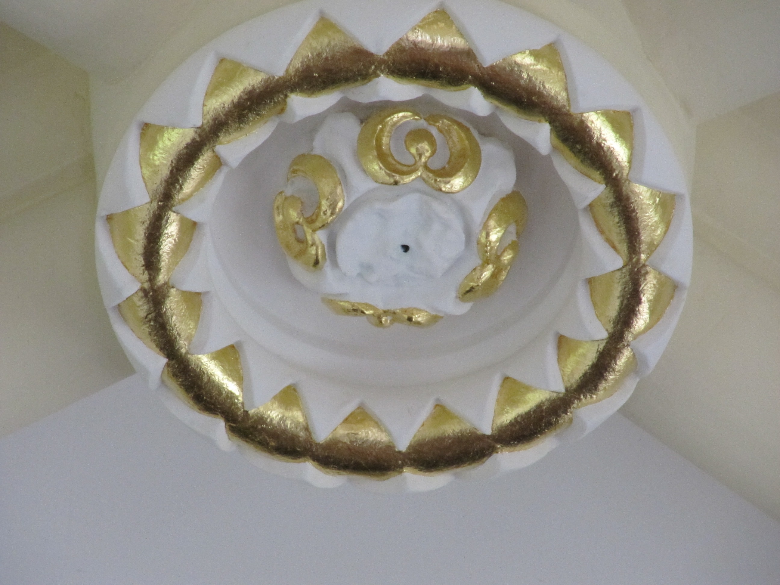Ornate gilded ceiling medallion with gold leaf detail
