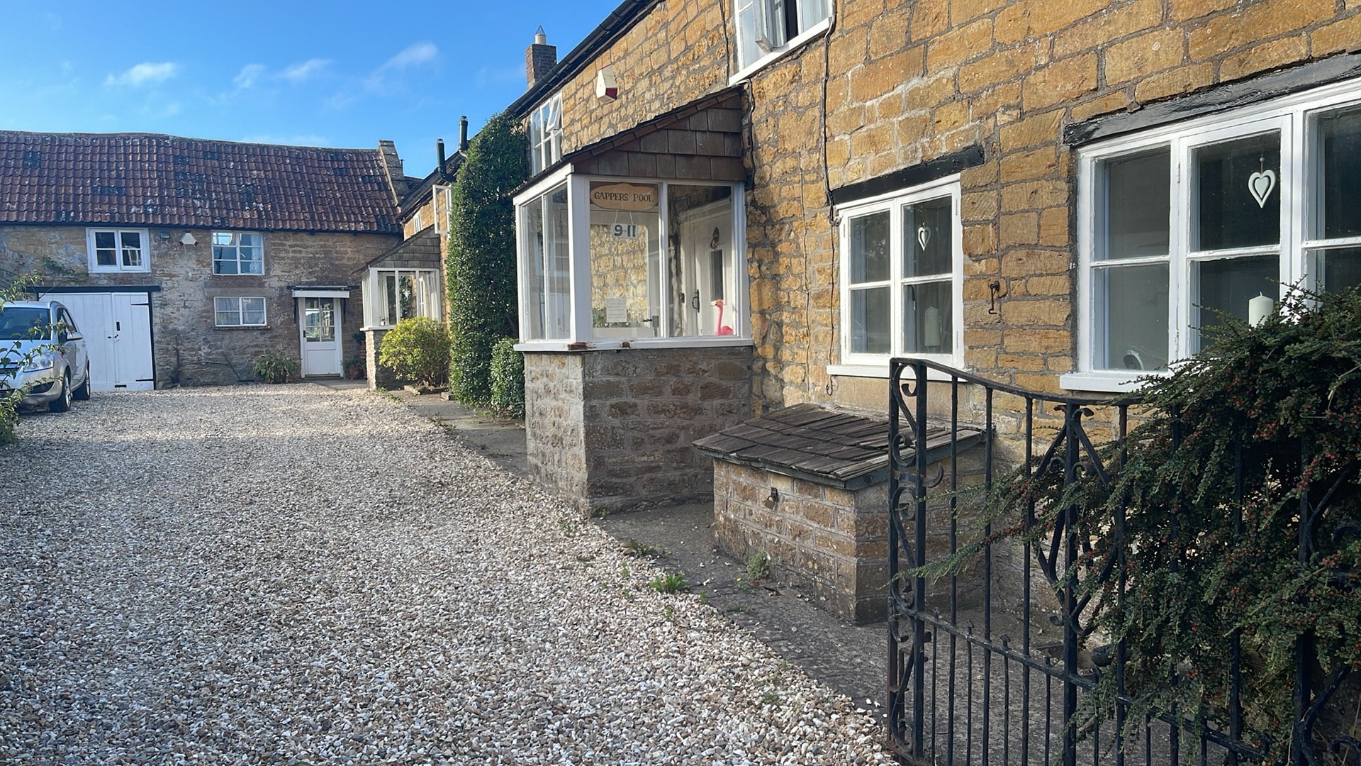 Stone cottages with gravel courtyard entrance — historic house restoration